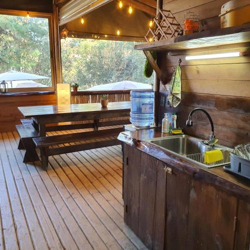 a kitchen with a sink and a bench on a deck at Glamping Puertecillo Surf & Camp in Puertecillo