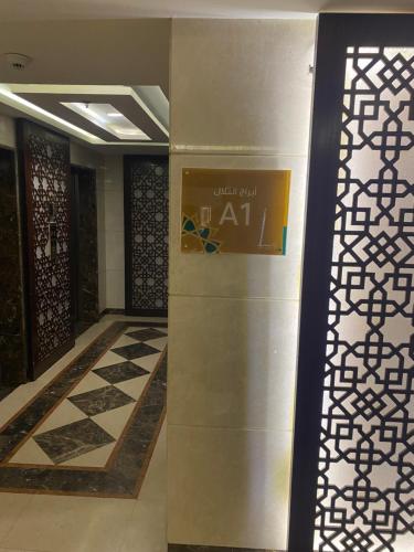 a lobby with a wall with a sign on it at شقة 3 غرف في أبراج التلال في مكة in Makkah