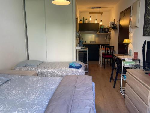 une petite chambre avec deux lits et une cuisine dans l'établissement Studio Cozy centre ville Chalon-sur-Saône, à Chalon-sur-Saône