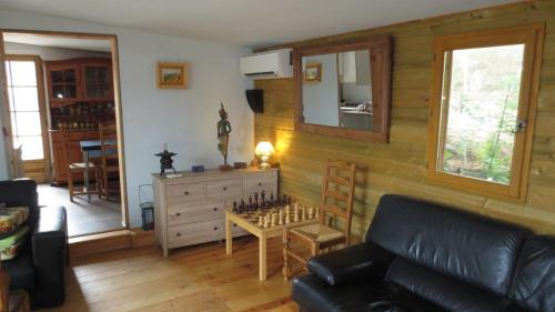 un salon avec un canapé en cuir et une table dans l'établissement chalet 4 à 6 pers à la campagne 15 mn plages et Ajaccio grand terrain arboré calme assuré, à Afa