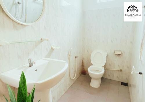 a bathroom with a toilet and a sink and a mirror at Sidhangana Home Stay in Anuradhapura