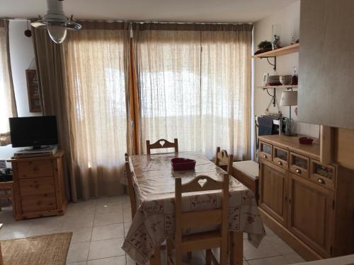 une cuisine avec une table et des chaises et une télévision dans l'établissement Appartement de charme à Vars les Claux, à Vars