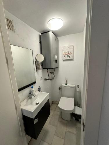 a bathroom with a toilet and a sink and a mirror at Casamar in Almería