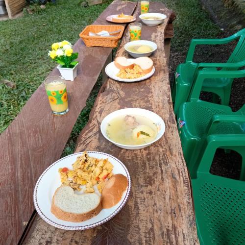 a wooden picnic table with plates of food on it at Glamping eco descanso la vega Nocaima in Nocaima