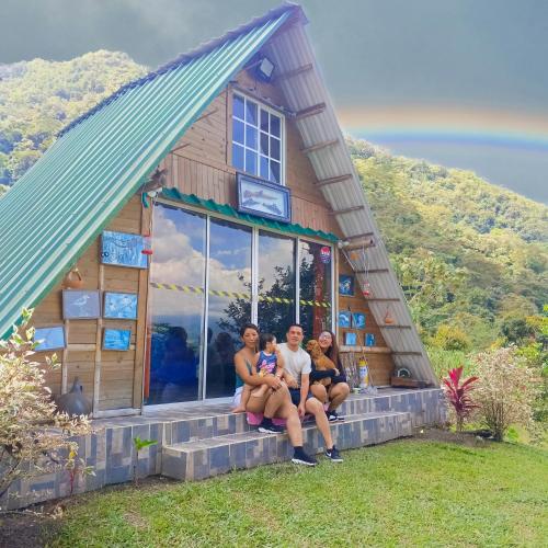 a family sitting in front of a tiny house at Glamping eco descanso la vega Nocaima in Nocaima