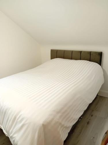 a white bed in a white room with white sheets at The Gamekeeper's Lodge in Ardara