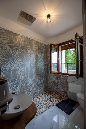 a bathroom with a wall with a leafy wallpaper at La terrazza sulle Madonie in Calcarelli