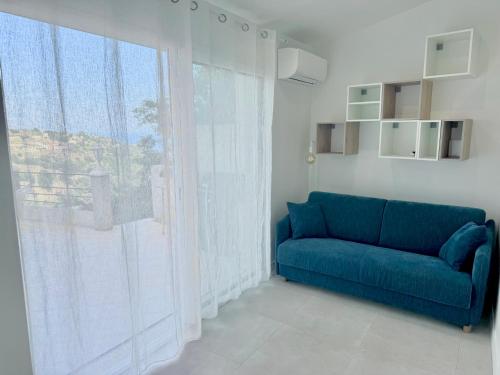 - un canapé bleu dans une chambre avec une grande fenêtre dans l'établissement 3 Studios indépendants dans villa avec piscine, à Nice