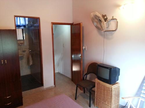 een kamer met een bed, een tv en een douche bij MaJoMi Toninas in Las Toninas