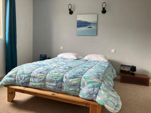 - un lit avec une couette dans une chambre dans l'établissement Belle maison familiale à Millau pour sportifs, à Millau