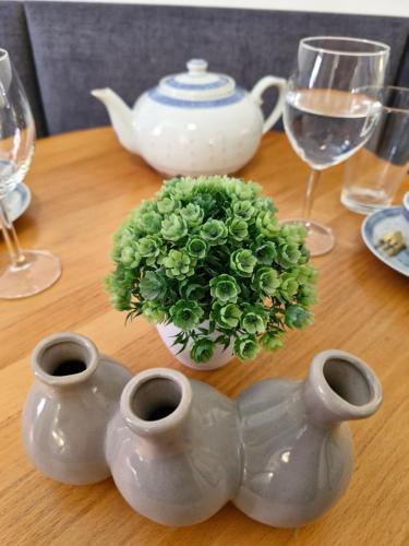 a table with a vase with a plant in it at Przy rynku in Duszniki Zdrój