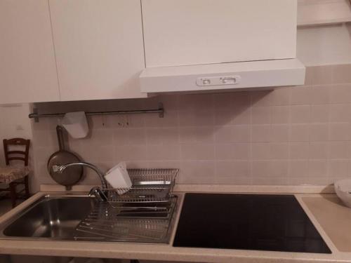 a kitchen with a sink and a dish drying rack at Casa alloggio Jolanda in Ceglie Messapica