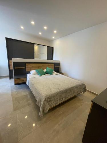 a bedroom with a large bed with green pillows at OpenView Apartment Marsaxlokk in Marsaxlokk