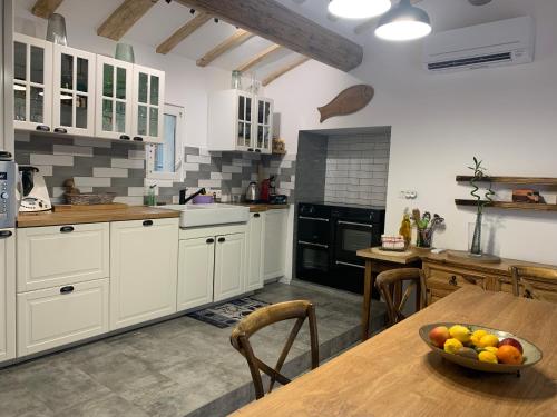 une cuisine avec une table avec un bol de fruits dessus dans l'établissement MAISON Ici, à Grimaud