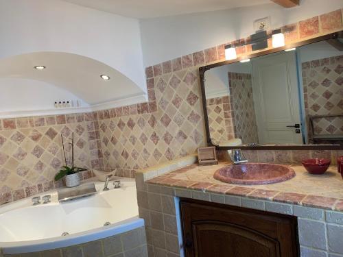 une salle de bain avec un lavabo et un miroir dans l'établissement MAISON Ici, à Grimaud