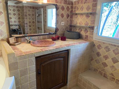 une salle de bain avec un lavabo et un miroir dans l'établissement MAISON Ici, à Grimaud