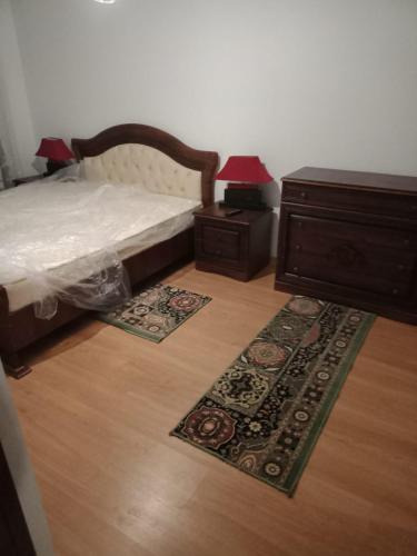 a bedroom with a bed and a dresser and a rug at Apartament luxury in Floreşti