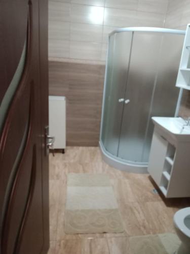 a bathroom with a glass shower and a sink at Apartament luxury in Floreşti