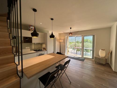 une cuisine avec une table et des chaises dans une pièce dans l'établissement Le Cabanon du Bonheur - 4 pers - Nyons, à Nyons