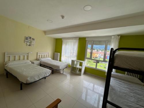 a bedroom with two beds and a large window at Albergue Internacional de Llanes in Llanes