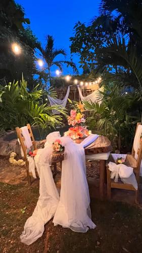 a table with a white table cloth and flowers on it at CHALET TROPICAL Hotel & Restaurant-Pizzeria in Las Galeras