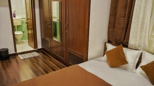 a bedroom with a bed and a bathroom at The Rustic Manor - Homestay in Bengaluru