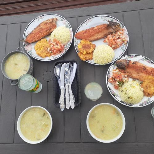 a table with plates of food and bowls of soup at Glamping eco descanso la vega Nocaima in Nocaima