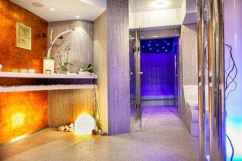 a bathroom with a walk in shower next to a tub at Niebieski Art Hotel & Spa in Krakow