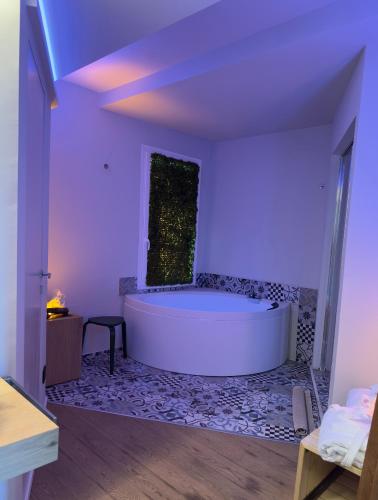 a large white bath tub in a room with purple lighting at URBAN PRIVATE SPA in Porto SantʼElpidio
