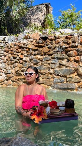 a woman in the water next to a waterfall at CHALET TROPICAL Hotel & Restaurant-Pizzeria in Las Galeras