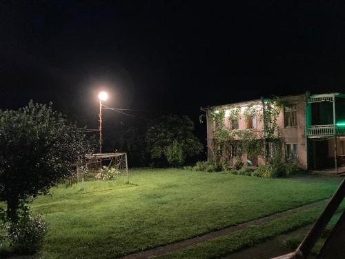 a yard at night with a house and a street light at Des Nana in Koko