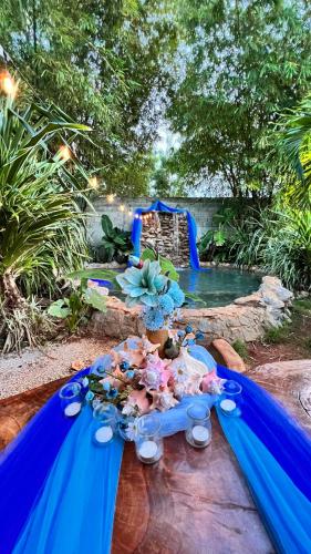 a table with a blue cloth and flowers on it at CHALET TROPICAL Hotel & Restaurant-Pizzeria in Las Galeras