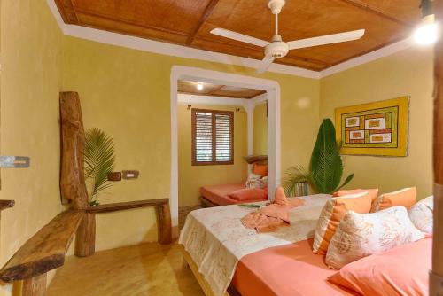 a bedroom with a bed and a ceiling fan at CHALET TROPICAL Hotel & Restaurant-Pizzeria in Las Galeras