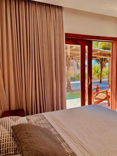 a bedroom with a bed and a sliding glass door at Bali BG Casa Bamboo in Barra Grande