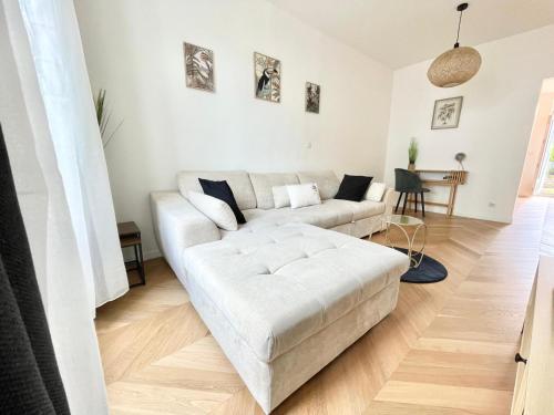 a living room with a white couch and a table at Appart Cosy Proche gare in Mantes-la-Jolie
