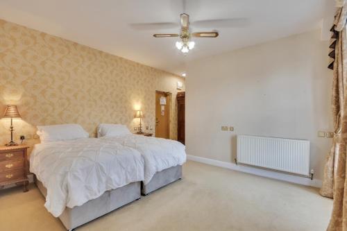 a bedroom with a large bed and a ceiling fan at White Waters Hotel in Llangollen