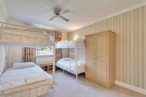 a bedroom with two bunk beds and a ceiling fan at White Waters Hotel in Llangollen