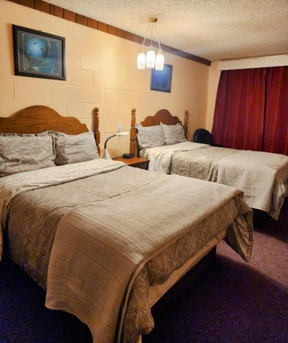 a hotel room with two beds in a room at Cedar Villa Motel in Foremost