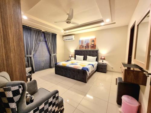 a bedroom with a bed and a couch and a chair at Executive 3 Bedrooms Apartment In Bahria Town in Rawalpindi