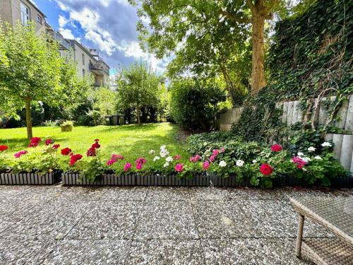a garden with pink and white flowers in a yard at Attraktive Wohnung im grünen Hinterhof in Schwerin