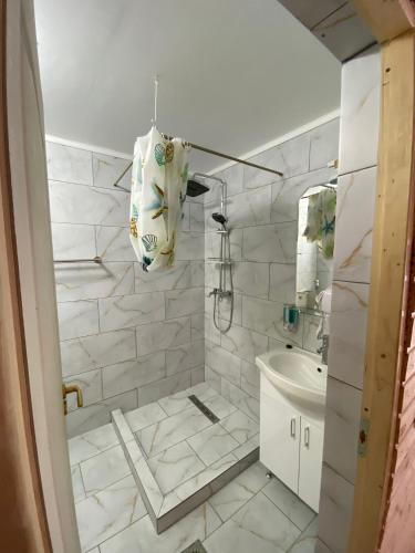 a white bathroom with a tub and a sink at Pensiunea Blue House in Vadu