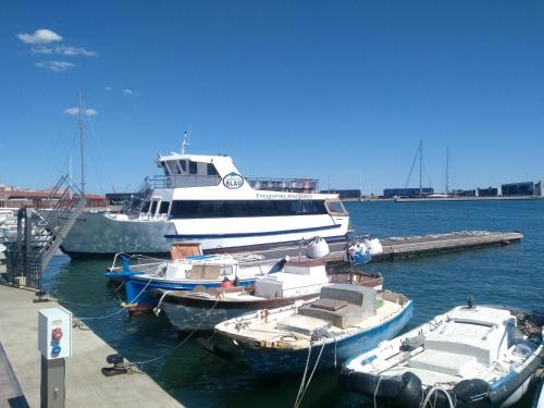 a large white boat docked at a dock with boats at Port PENTHOUSE in Tarragona
