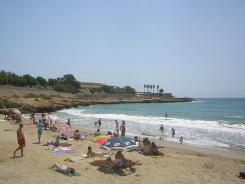 a group of people on a beach with the ocean at Port PENTHOUSE in Tarragona