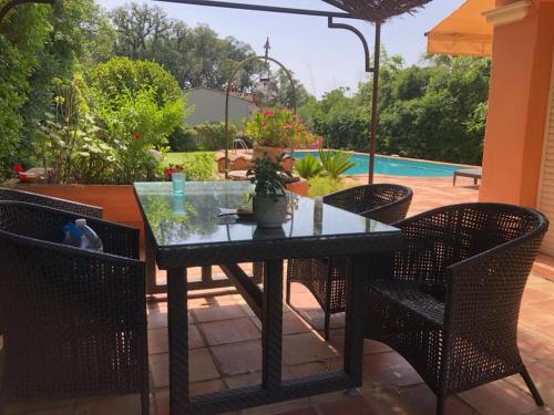 une table et des chaises en verre sur la terrasse dans l'établissement Petite maison à l'entrée de Saint-Tropez, à Saint-Tropez