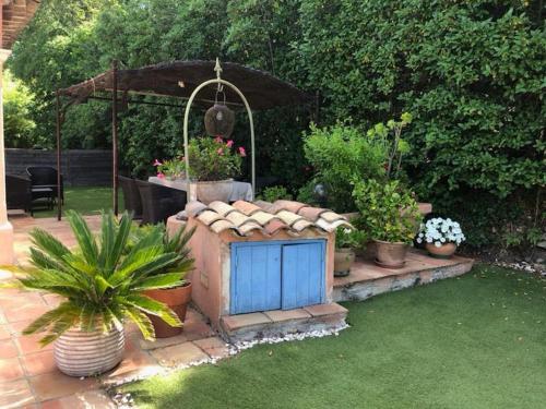 un jardin avec des plantes en pot et une porte bleue dans l'établissement Petite maison à l'entrée de Saint-Tropez, à Saint-Tropez