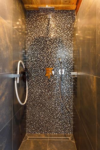 a bathroom with a shower with a tile wall at Spreewald Chalet Wohnung 1 Spreeblick in Burg