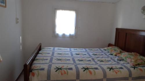 une chambre avec un lit avec une couette dessus dans l'établissement Petite Maison au barcares 4 personnes, au Barcarès