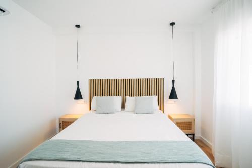 a bedroom with a large white bed with two pillows at Almare Suites - Aguadulce Vistas al mar in Aguadulce