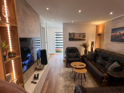 a living room with a couch and a flat screen tv at Ferienwohnung E in Soltau