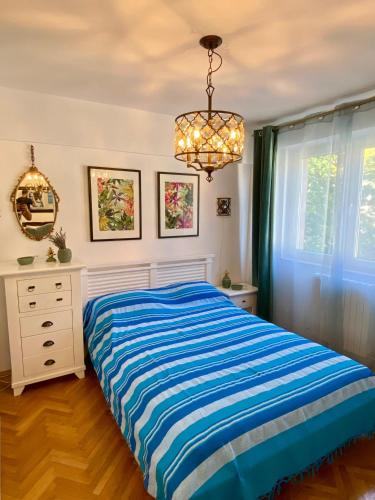 a bedroom with a bed and a dresser and a chandelier at Old Town Apartment in Constanţa